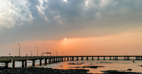 Pier over sea against sky during sunset