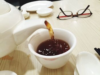 Close-up of chinese tea being poured in cup on table