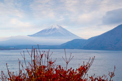 Scenic view of lake and snowcapped mountains against sky