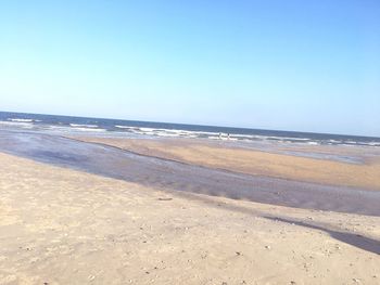 Scenic view of beach against clear blue sky