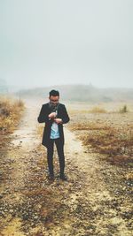 Full length of man standing on ground against sky