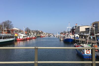 Sailboats moored at harbor in city