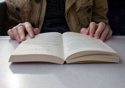 Midsection of woman reading book