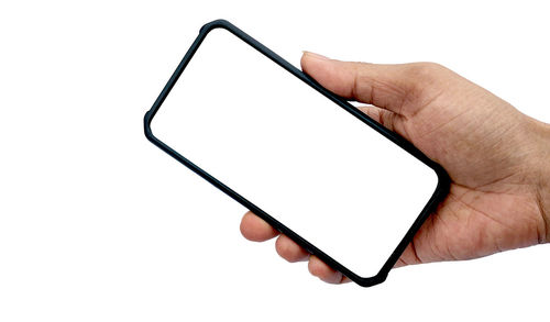 Low section of person holding smart phone against white background