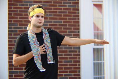 Portrait of man standing against brick wall