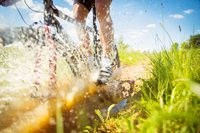 Low section of man with bicycle in water