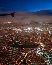 Aerial view of illuminated cityscape against sky at night