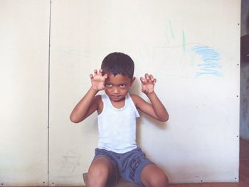 Portrait of cute boy against wall at home