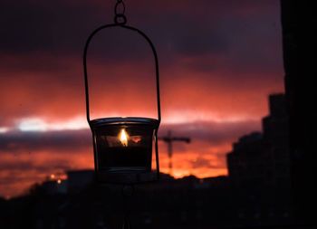 Close-up of illuminated lamp against sky at sunset