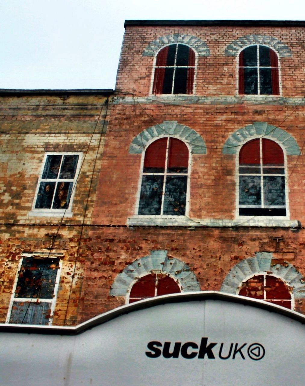 architecture, building exterior, built structure, window, arch, low angle view, building, brick wall, facade, text, day, western script, outdoors, history, no people, old, wall - building feature, wall, clear sky, city