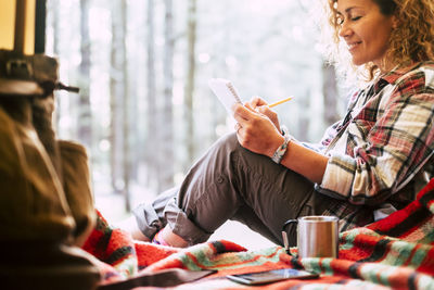 Woman using smart phone while sitting on table