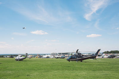 Airplane flying over field against sky