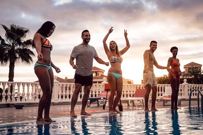 Group of people at swimming pool against sky