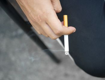 Close-up of hand holding cigarette