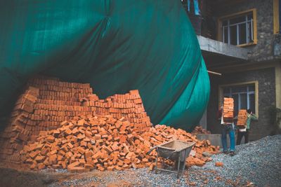 Workers working by bricks at construction site