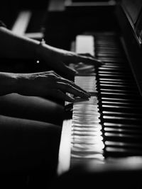 Cropped image of person playing piano