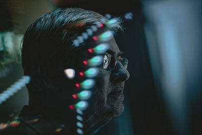 Close-up senior man sitting in darkroom