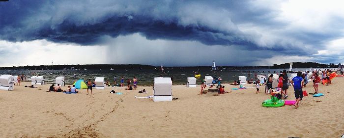 Panoramic view of people on beach against sky