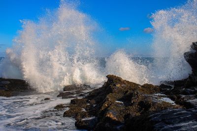Waves splashing on rocks against sea