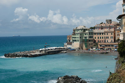 Scenic view of sea by buildings against sky