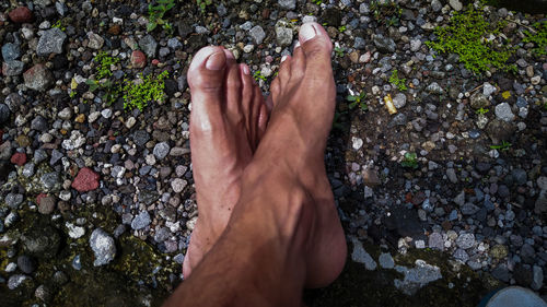 Low section of person legs on pebbles