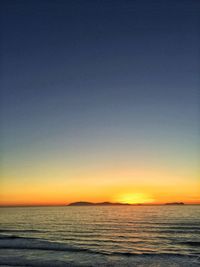 Scenic view of sea against clear sky at sunset