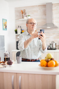 Senior man using smart phone at home
