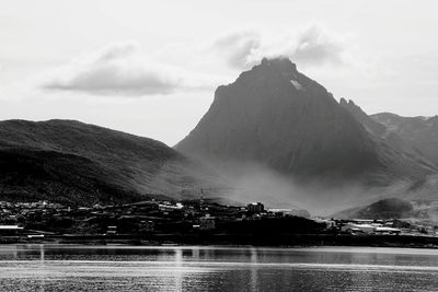 Scenic view of lake by mountains against sky