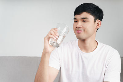 Portrait of young man drinking glasses