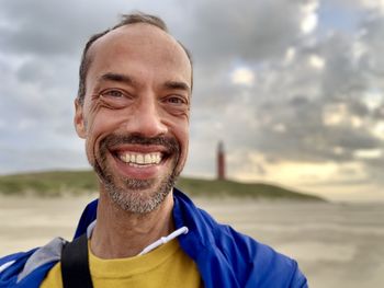 Portrait of smiling man standing at beach