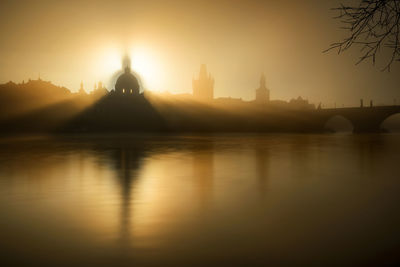 Reflection of buildings in river at sunset