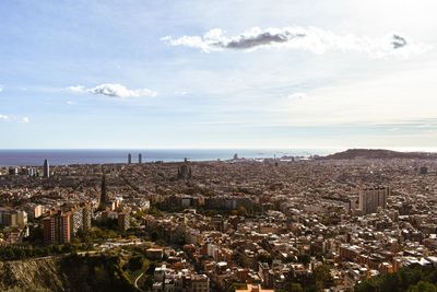 High angle view of city by sea against sky