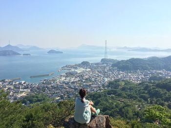 High angle view of woman sitting on mountain