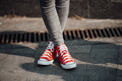 Low section of woman standing on footpath