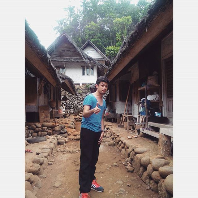 YOUNG MAN STANDING IN FRONT OF HOUSE