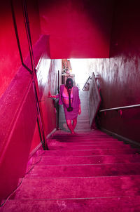 High angle view of woman with gas mask walking on illuminated steps in building