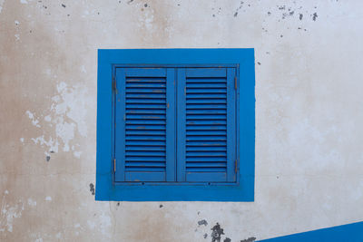 Close-up of blue window on wall of building