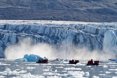 Melting glacier calves in front of arctic expedition zodiacs.