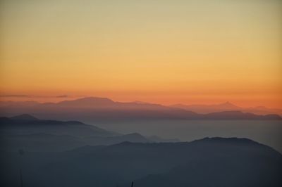 Scenic view of silhouette mountains against romantic sky at sunset