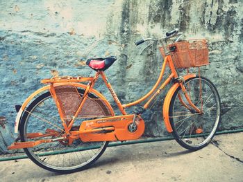 Bicycle parked against wall in city