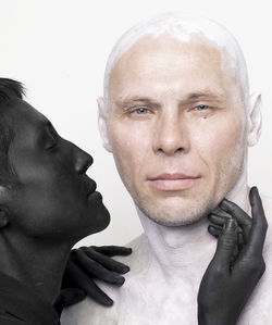 Close-up of people with painted body against white background