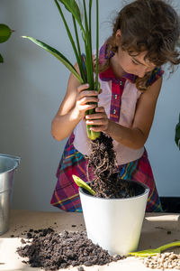 Portrait of woman holding potted plant