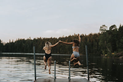 Women jumping together into water