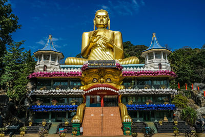 Statue in temple building against sky