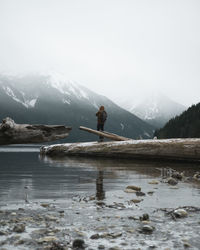 Scenic view of lake by snowcapped mountains against sky