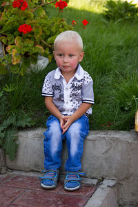 Portrait of cute boy sitting outdoors