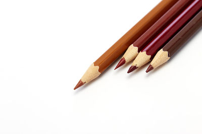 High angle view of colored pencils on white background