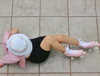 High angle view of woman lying down on tiled floor