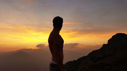 Silhouette woman standing against sky during sunset