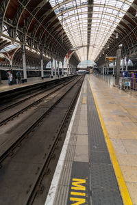 Inside large london train station glass and steel roof view along platform